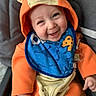 baby, child, smiling, happy, portrait, orange_outfit, animal_hood, hooded_clothing, bib, car_seat, seated, infant, face, hands, indoor, close_up, colorful, cute, photography, joy