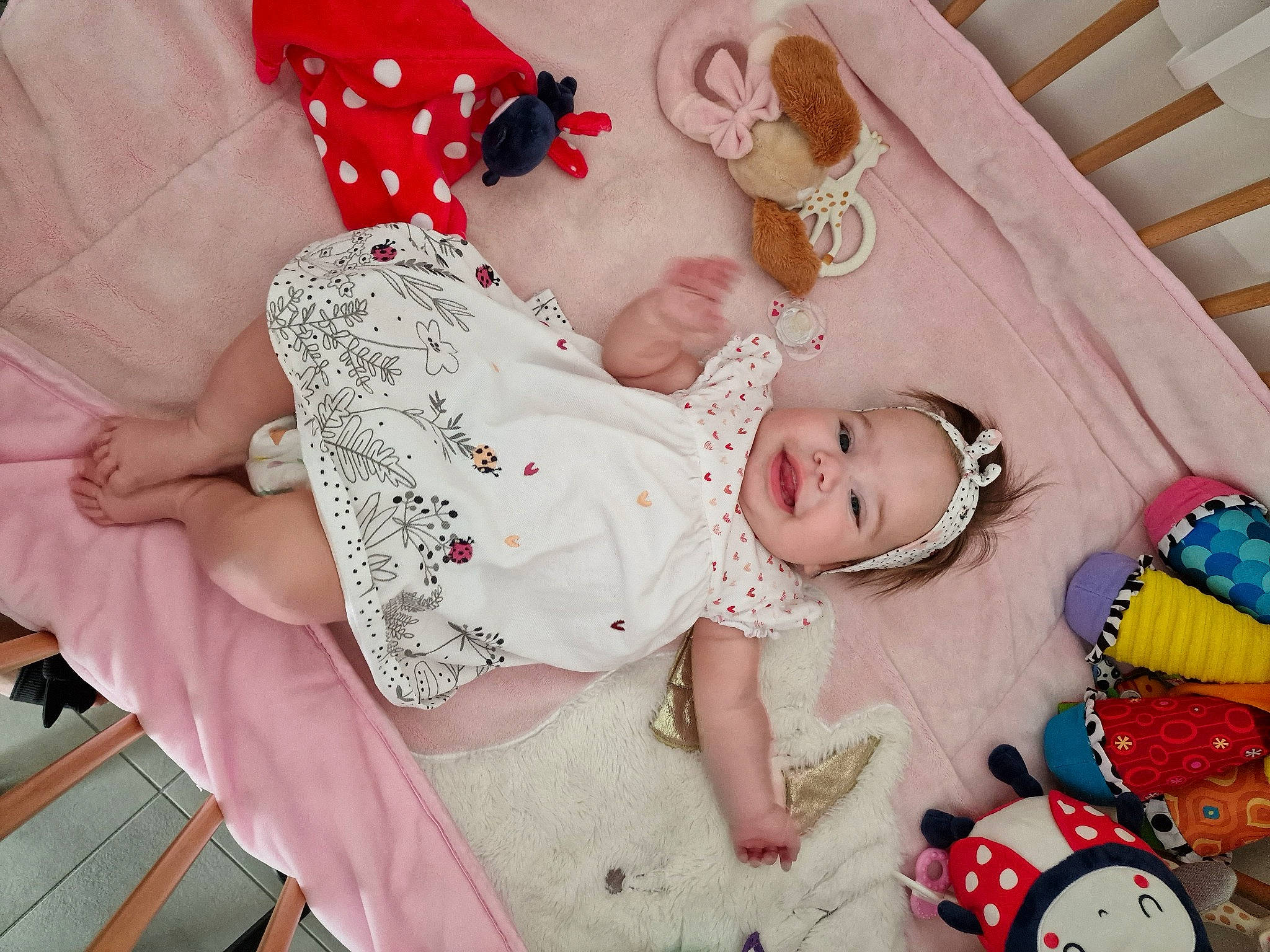 Aria a rejoint le concours — aidez-le/la à gagner de superbes lots ! baby, baby_products, baby_toddler_clothing, cheek, child, comfort, embellishment, fashion_accessory, happy, headband, headwear, linens, organ, pattern, person, pink, red, skin, sleeve, textile