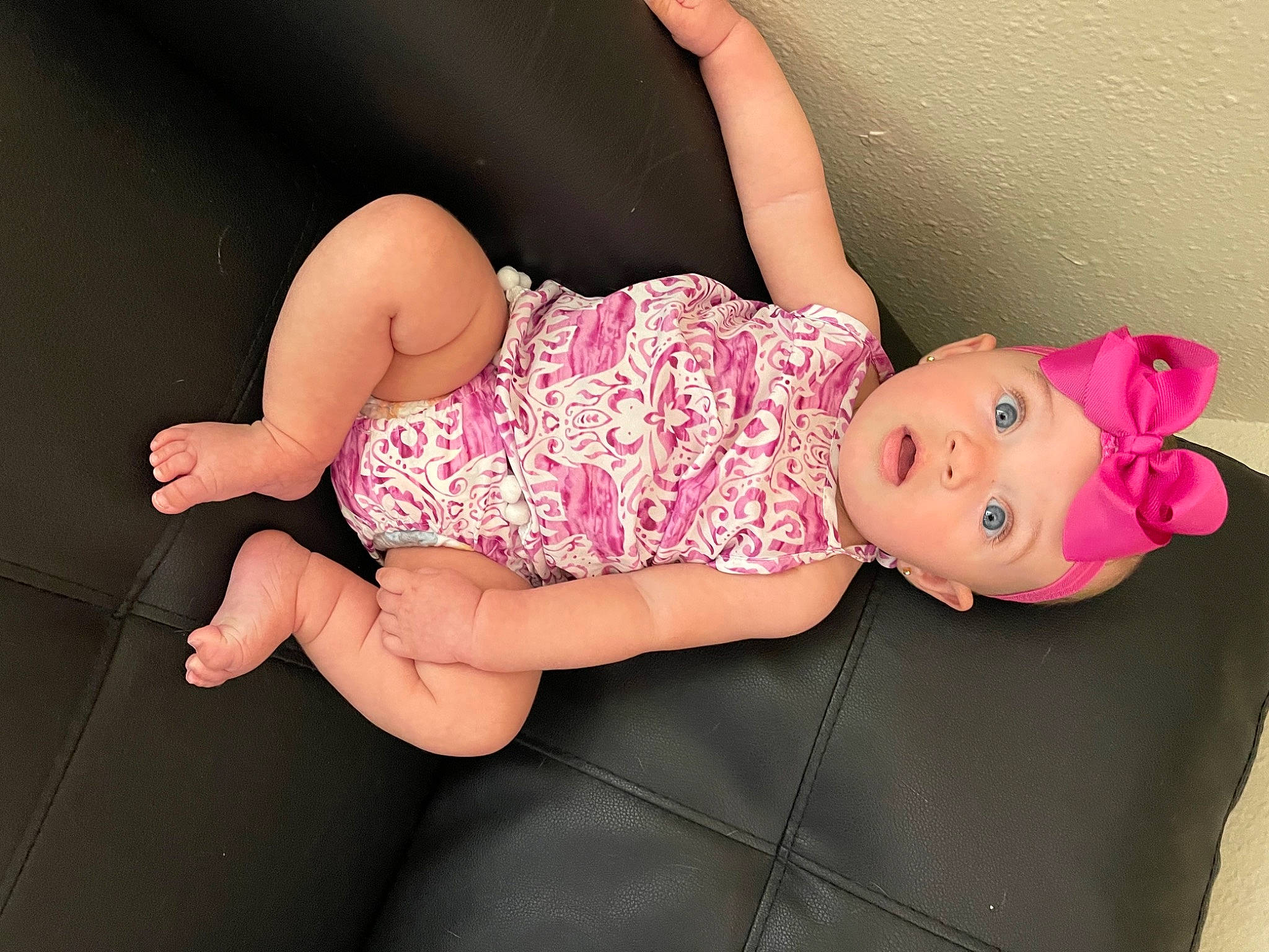 Hailey is registered to the contest to win money with this photo: arm, baby_toddler_clothing, child, finger, foot, hand, head, headgear, headwear, human_body, human_leg, joint, knee, leg, pattern, person, pink, skin, sleeve, surprise