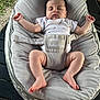 baby, sleeping, baby_seat, gray, outdoor, grass, relaxed, infant, child, cute, peaceful, comfort, arms_outstretched, legs, feet, white_clothing, patterned_onesie, padded_seat, babygear, portrait