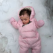 Lilybeth is registered to the contest to win money with this photo: baby, child, snow, pink_snowsuit, sleeping, outdoor, winter, headband, cute, cold_weather, infant, one_person, clothing, footwear, nature, laying_down, face, peaceful, winter_clothes, snowy_background
