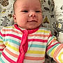 Lya participe au concours pour gagner de l'argent avec cette photo : baby, infant, smiling, striped_clothing, onesie, face, child, cute, lying_down, cushion, patterned_fabric, animal_print, comfort, happy, indoors, portrait, closeup, soft_lighting, newborn, expression