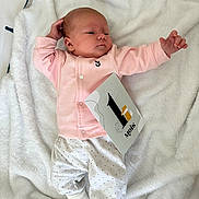 Lya a rejoint le concours — aidez-le/la à gagner de superbes lots ! baby, infant, blanket, pink_jacket, polka_dot_pants, milestone_card, white_socks, newborn, soft_texture, lying_down, cute, portrait, resting, one_month, indoors, sleepy, child, person, cozy, baby_clothes