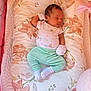 baby, newborn, sleeping, crib, pillow, floral_pattern, onesie, mittens, socks, green_pants, baby_wipes, pampers, blanket, soft_toys, infant, rest, cozy, nursery, baby_care, peaceful