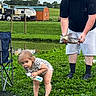 Amiyah is registered to the contest to win money with this photo: beard, bottle, camping_chair, catch, clothing, daylight, fish, grass, greenery, hat, man, nature, net, outdoor, pond, recreational_fishing, rural, smile, toddler, water