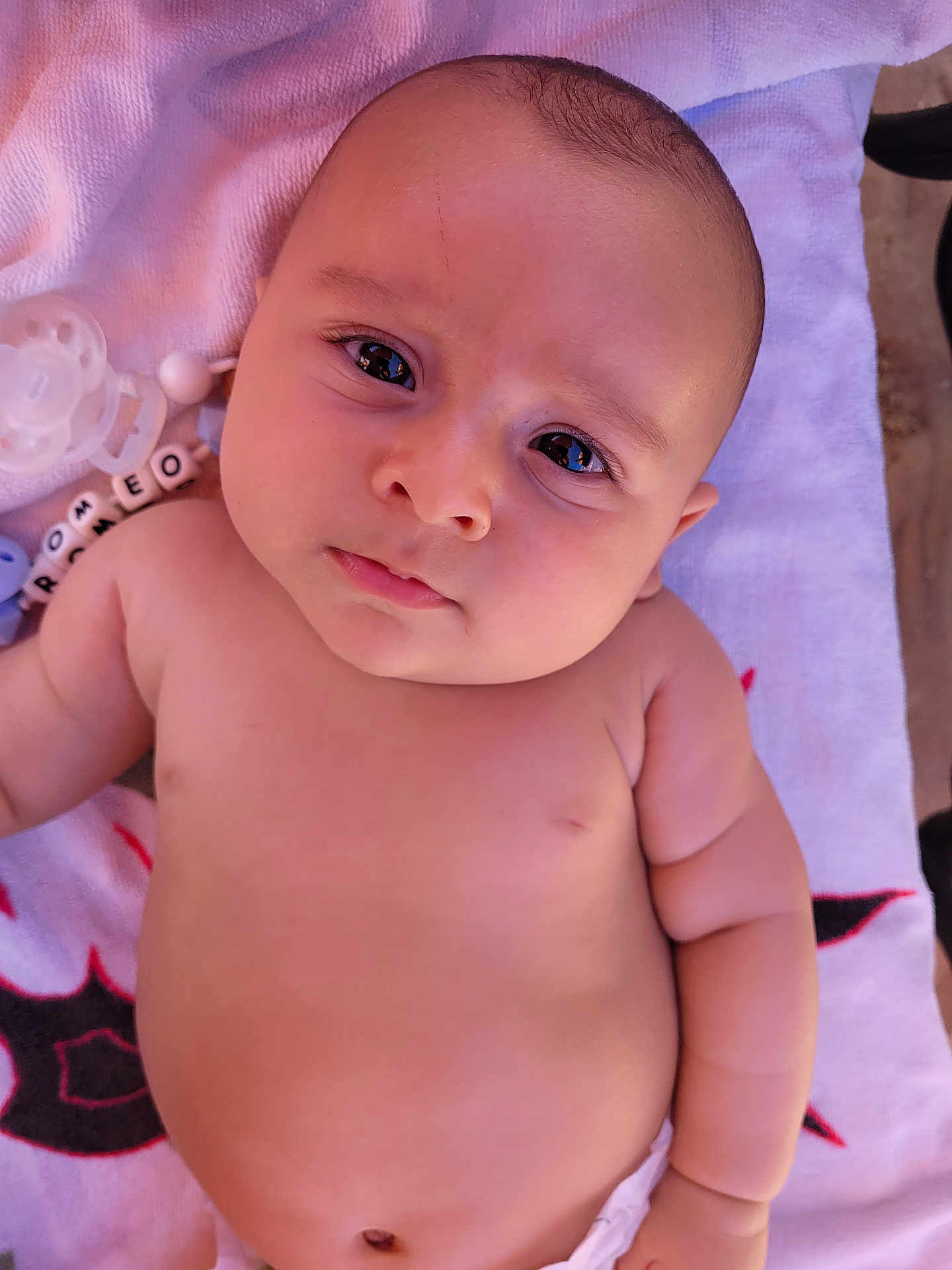Roméo participe au concours pour gagner de l'argent avec cette photo : baby, infant, face, skin, eyes, pacifier, towel, diaper, arm, chubby, expression, closeup, cute, child, newborn, lying_down, indoors, person, adorable, portrait