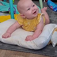 Destiny is registered to the contest to win money with this photo: baby, infant, child, smiling, happy, portrait, tummy_time, yellow_outfit, play_mat, baby_cushion, toy, play_gym, bookshelf, indoor, home, floor, carpet, sitting, face, photography