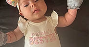 Alora is registered to the contest to win money with this photo: apparel, baby, bow, child, clothing, cute, expression, fabric, floral, headband, infant, lying_down, mama_bestie, mittens, onesie, person, pink, portrait, sleepwear, soft_light
