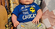 Wyatt is registered to the contest to win money with this photo: baby, blanket, blue_shirt, chick_design, child, couch, cozy, furniture, graphic_tshirt, home, indoors, infant, pants, pillow, portrait, shoes, sitting, sunglasses_graphic, text_on_clothing, wide_eyed