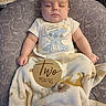 baby, infant, sleeping, portrait, two_months, blanket, cushion, onesie, stitch_clothing, wooden_sign, milestone, indoor, cozy, head, face, hands, arms, elephant_pattern, nursery, peaceful
