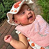 Kiylah is registered to the contest to win money with this photo: baby, smiling, hat, bib, outdoor, greenery, brick_path, infant, cute, happy, child, person, apparel, headwear, nature, hand, skin, portrait, sunhat, embroidery