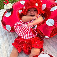 Kiylah joined the competition — help win amazing prizes! baby, child, birthday, cupcake, candle, red, polka_dot, hat, inflatable_ring, grass, blanket, smiling, cute, celebration, outdoor, happy, clothing, festive, food, person