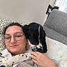 Charly a rejoint le concours — aidez-le/la à gagner de superbes lots ! woman, person, dog, pet, black_and_white, cuddling, sofa, couch, indoor, living_room, portrait, glasses, long_hair, relaxed, sleeping, floppy_ears, blanket, hand, window, cozy