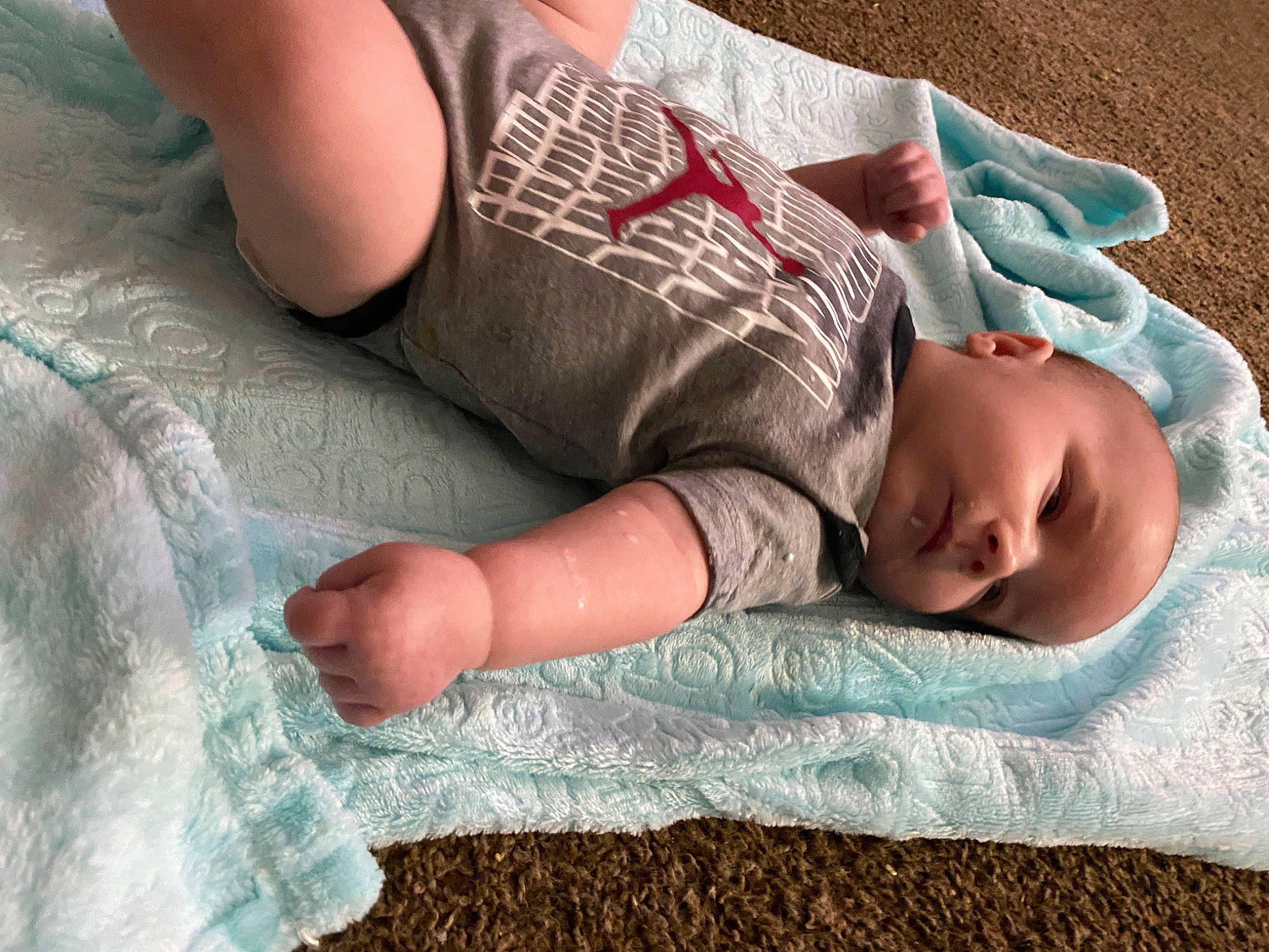 Killian joined the competition — help win amazing prizes! baby, baby_toddler_clothing, bed_sheet, bedding, bedtime, child, comfort, elbow, finger, gesture, grass, human_body, human_leg, linens, pattern, person, sleeve, t_shirt, textile, thigh
