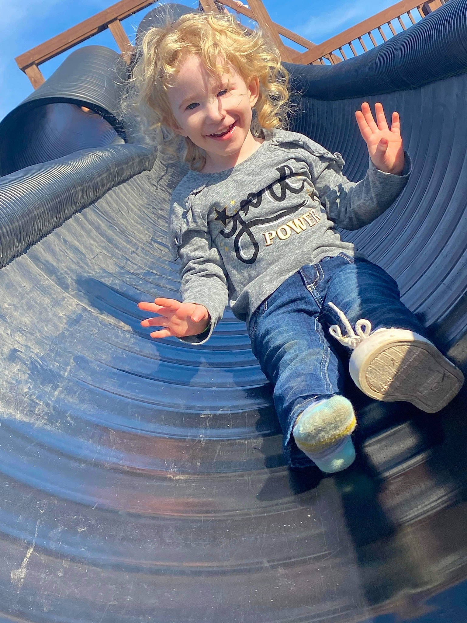 Katara is registered to the contest to win money with this photo: blue, child, city, denim, electric_blue, eye, flash_photography, fun, happy, human_body, joy, leisure, outdoor_play_equipment, person, playground, recreation, sitting, sky, smile, t_shirt