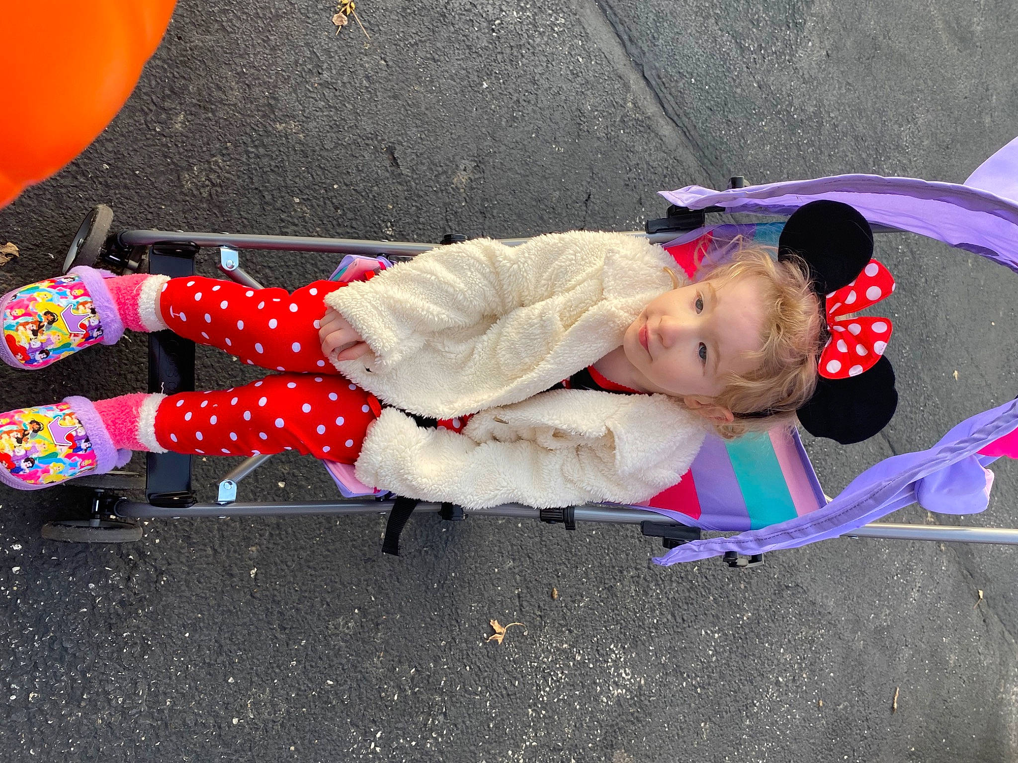 Katara is registered to the contest to win money with this photo: asphalt, balloon, carmine, child, city, concrete, electric_blue, fun, human_leg, knee, leisure, pattern, person, recreation, road_surface, shadow, sidewalk, sitting, sneakers, thigh