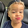 Elijah is registered to the contest to win money with this photo: child, curly_hair, cap, backwards_cap, smile, face, car_seat, seat, clothing, person, portrait, cute, expression, young, kid, sitting, indoor, vehicle, head, playful