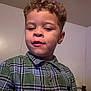 Elijah is registered to the contest to win money with this photo: child, boy, curly_hair, plaid_shirt, indoor, portrait, casual, young, face, person, clothing, childhood, expression, wall, door, buttoned_shirt, head, skin, hair, room