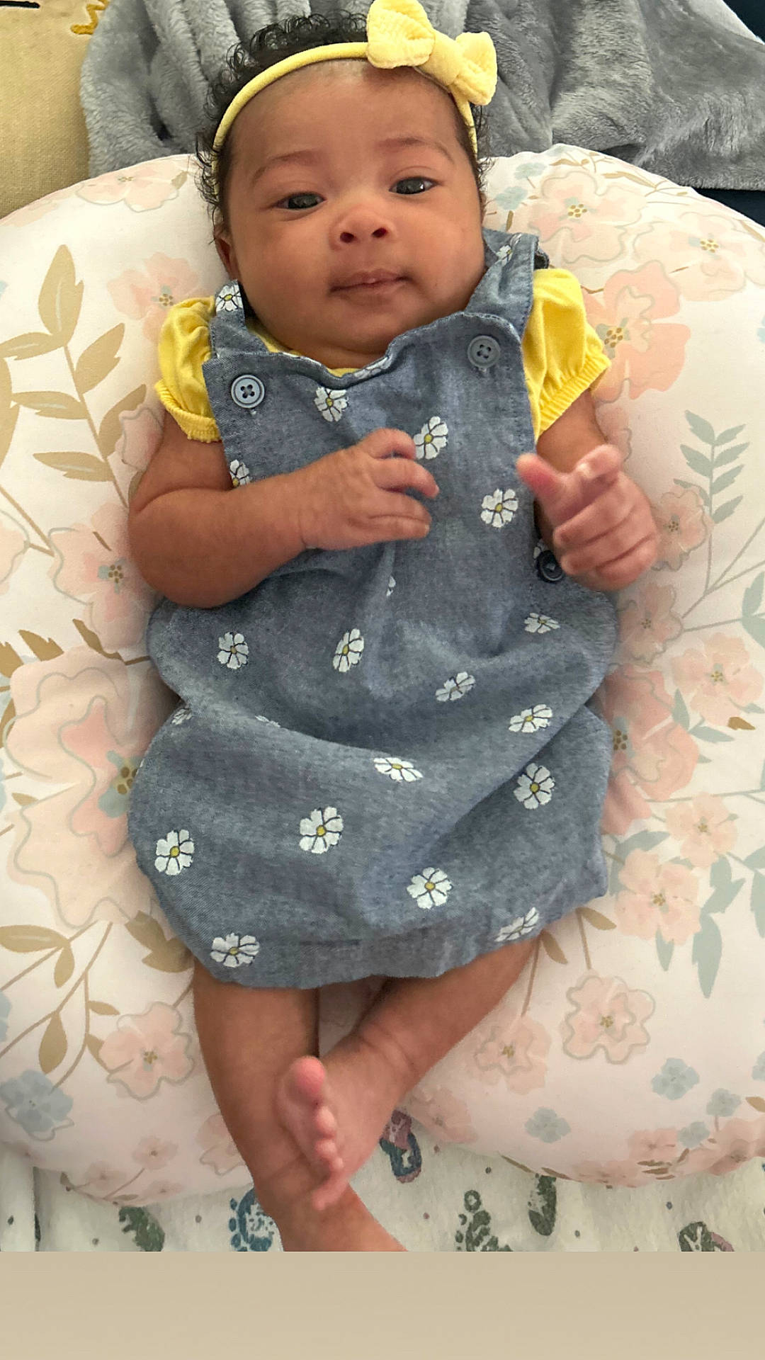 Averi is registered to the contest to win money with this photo: accessories, baby, bodypart, bonnet, clothing, couch, dress, face, finger, furniture, hand, hat, head, homedecor, newborn, pants, person, photography, portrait, sitting