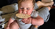 Jaxon joined the competition — help win amazing prizes! adult, baby, black_couch, child, clothing, couch, cracker, eating, face, family, funny, gray_outfit, hands, home, indoor, infant, legs, portrait, sitting, snack