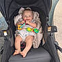 baby, stroller, toy, blanket, smile, infant, outdoor, foot, clothing, person, seat, play, happy, child, relax, cute, comfort, fabric, head, hand