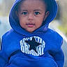 toddler, child, hoodie, blue_clothing, star_logo, outdoor, portrait, cute, face, young_child, fashion, casual_wear, sitting, person, smiling, closeup, baby, headwear, jacket, leisure