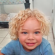 Cecil is registered to the contest to win money with this photo: baby_toy, blonde_hair, blue_eyes, casual_clothing, child, childhood, curly_blonde, curly_hair, cute, floor, happy, home, indoor, person, playpen, portrait, smiling, tile, toy, young