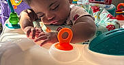 Chloe is registered to the contest to win money with this photo: baby, toddler, sleeping, activity_center, toys, colorful, indoor, child, window_blinds, sunlight, pout, hand, feet, playmat, plastic, furniture, cute, peaceful, infant, home