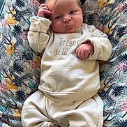 Manaé participe au concours pour gagner de l'argent avec cette photo : baby, newborn, infant, child, cushion, patterned, clothing, socks, face, hand, cozy, indoors, cute, expression, resting, soft, fabric, portrait, person, home