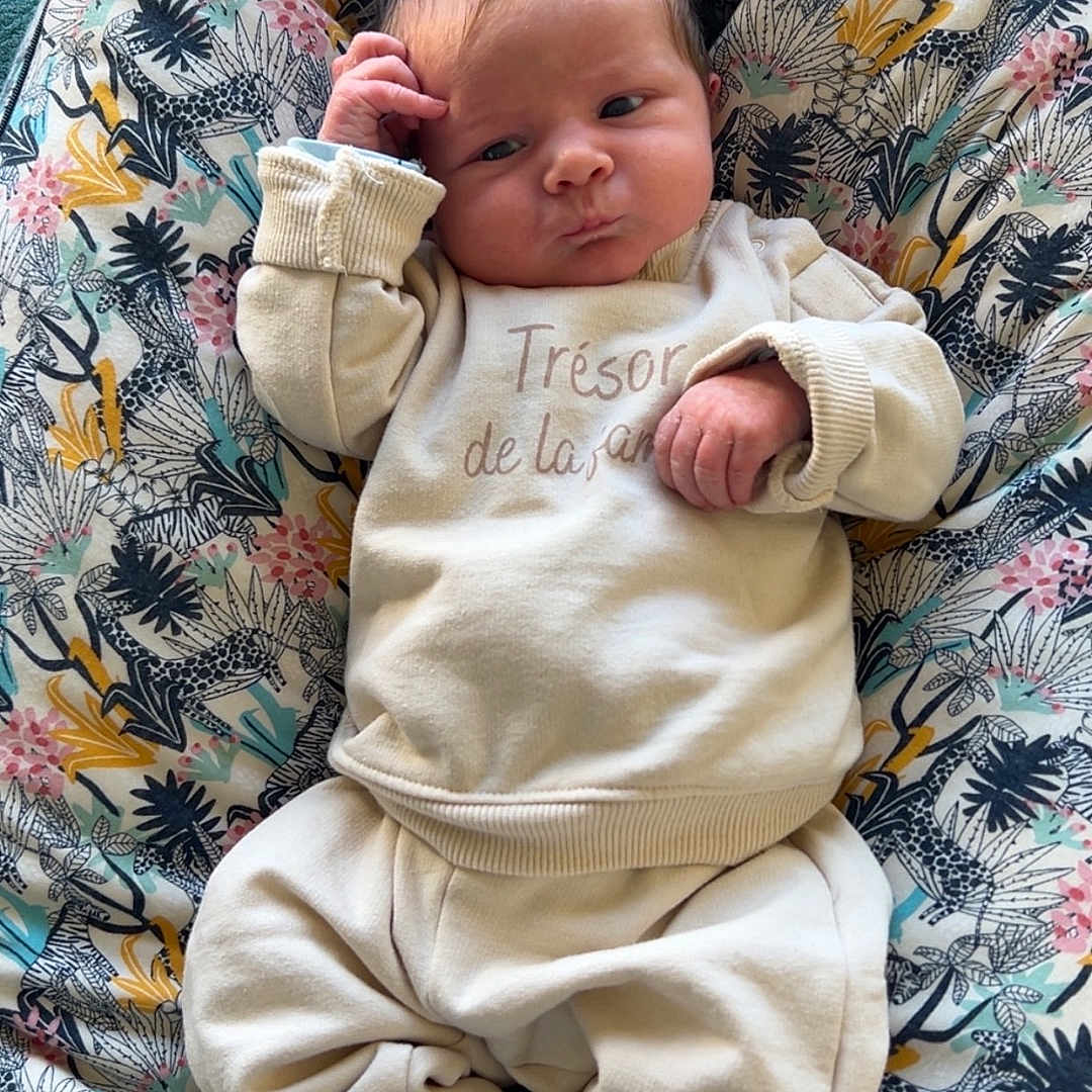 Manaé participe au concours pour gagner de l'argent avec cette photo : baby, child, clothing, cozy, cushion, cute, expression, fabric, face, hand, home, indoors, infant, newborn, patterned, person, portrait, resting, socks, soft