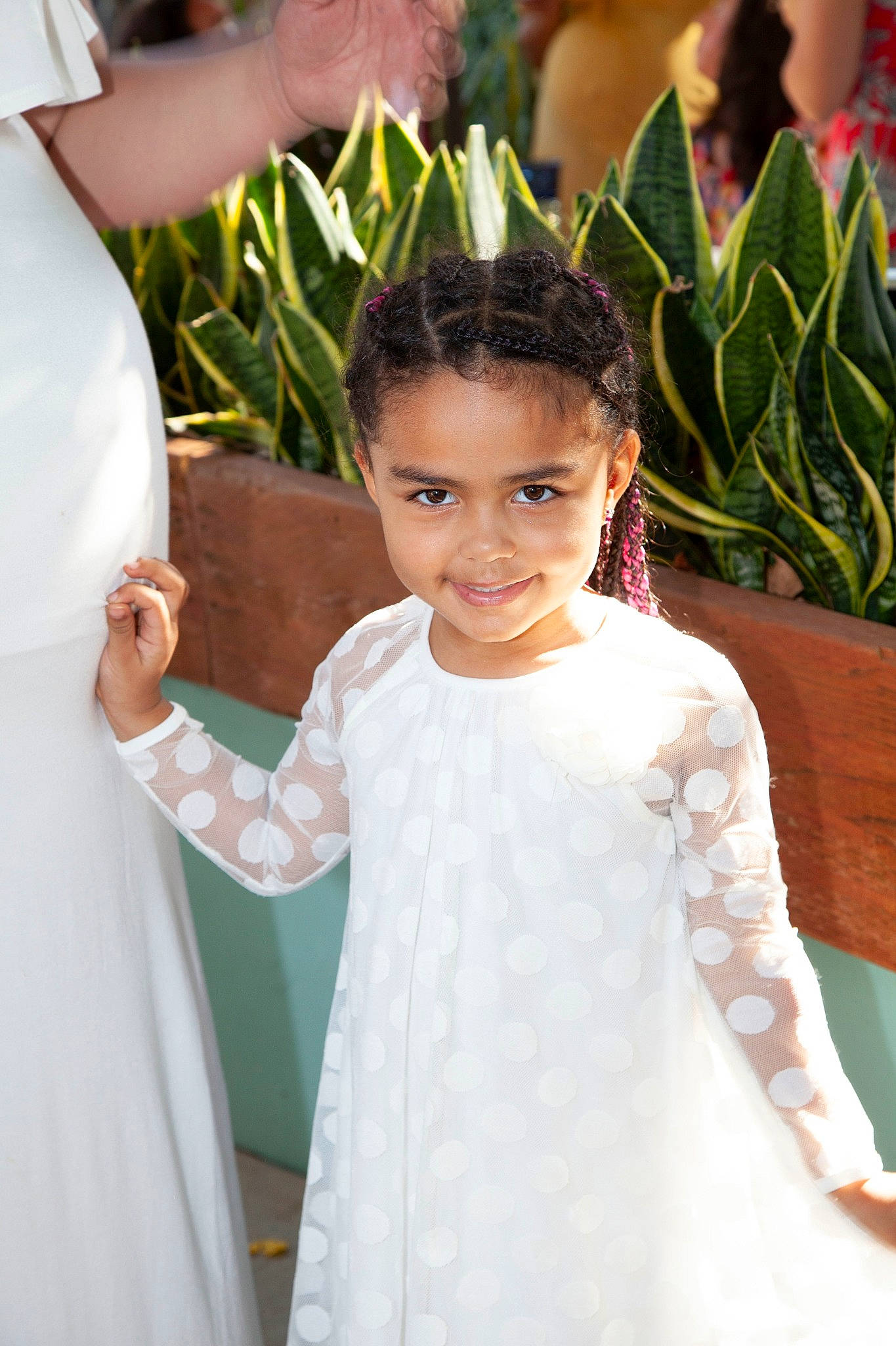 Maia is registered to the contest to win money with this photo: baby_toddler_clothing, ceremony, child, child_model, day_dress, dress, embellishment, gesture, hair_accessory, happy, joy, person, ritual, textile, tradition, white