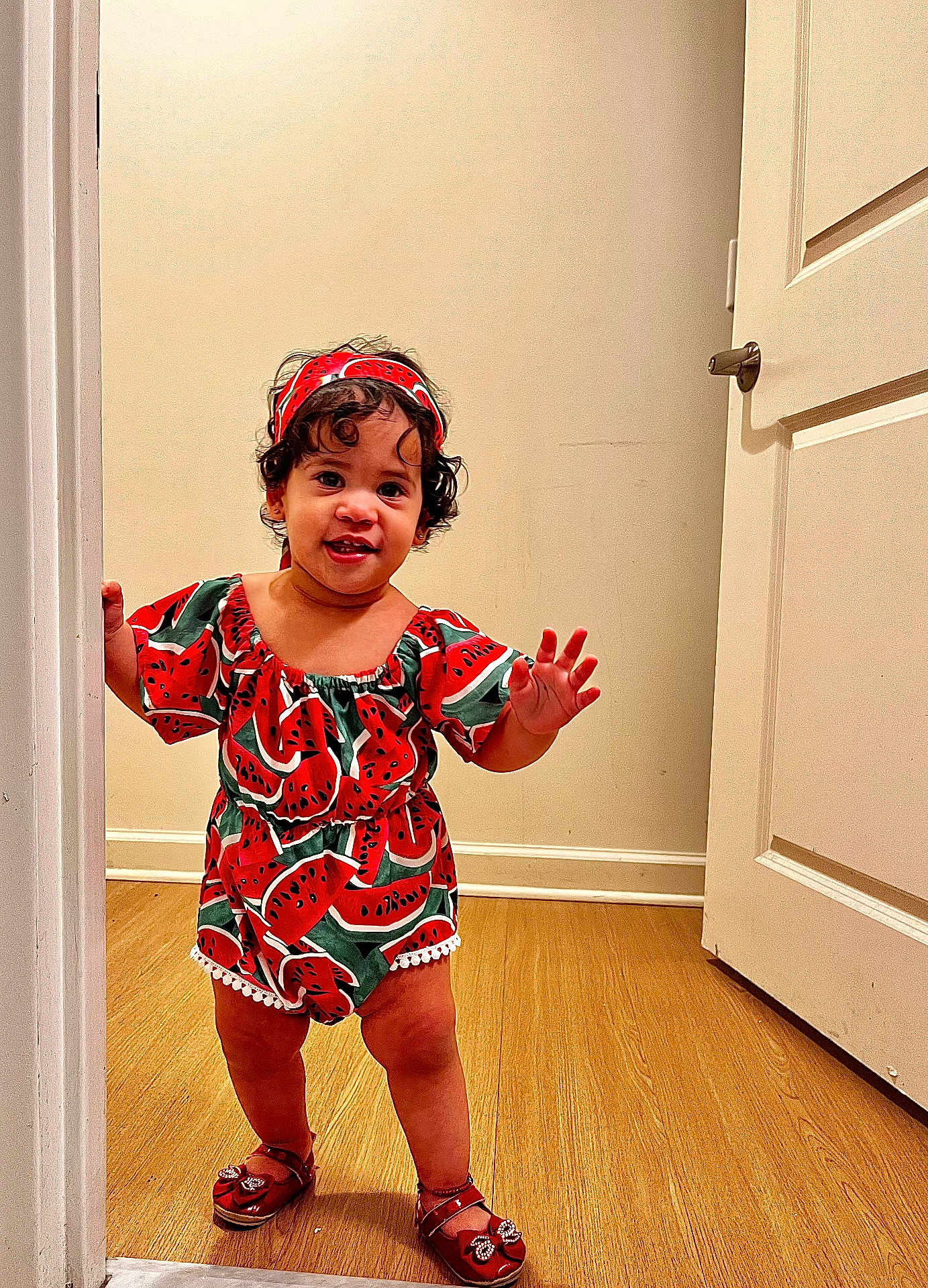 Cattleya joined the competition — help win amazing prizes! toddler, child, standing, watermelon_print, headband, red_shoes, doorway, wooden_floor, smiling, curly_hair, indoor, cute, fashion, happy, person, clothing, footwear, playful, young_child, portrait