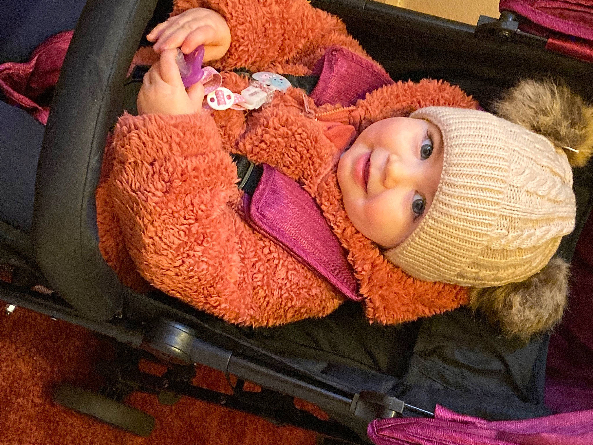 Isla joined the competition — help win amazing prizes! baby, baby_products, cap, car_seat, child, comfort, craft, fur, hand, head, headwear, human_body, knit_cap, magenta, person, textile, thread, toddler, vehicle_door, wool