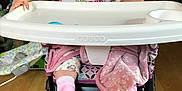 Athena joined the competition — help win amazing prizes! baby, high_chair, bib, smile, indoor, child, pink_socks, blanket, wood_floor, face, person, happy, cute, table, clothing, hand, footwear, infant, expression, seat