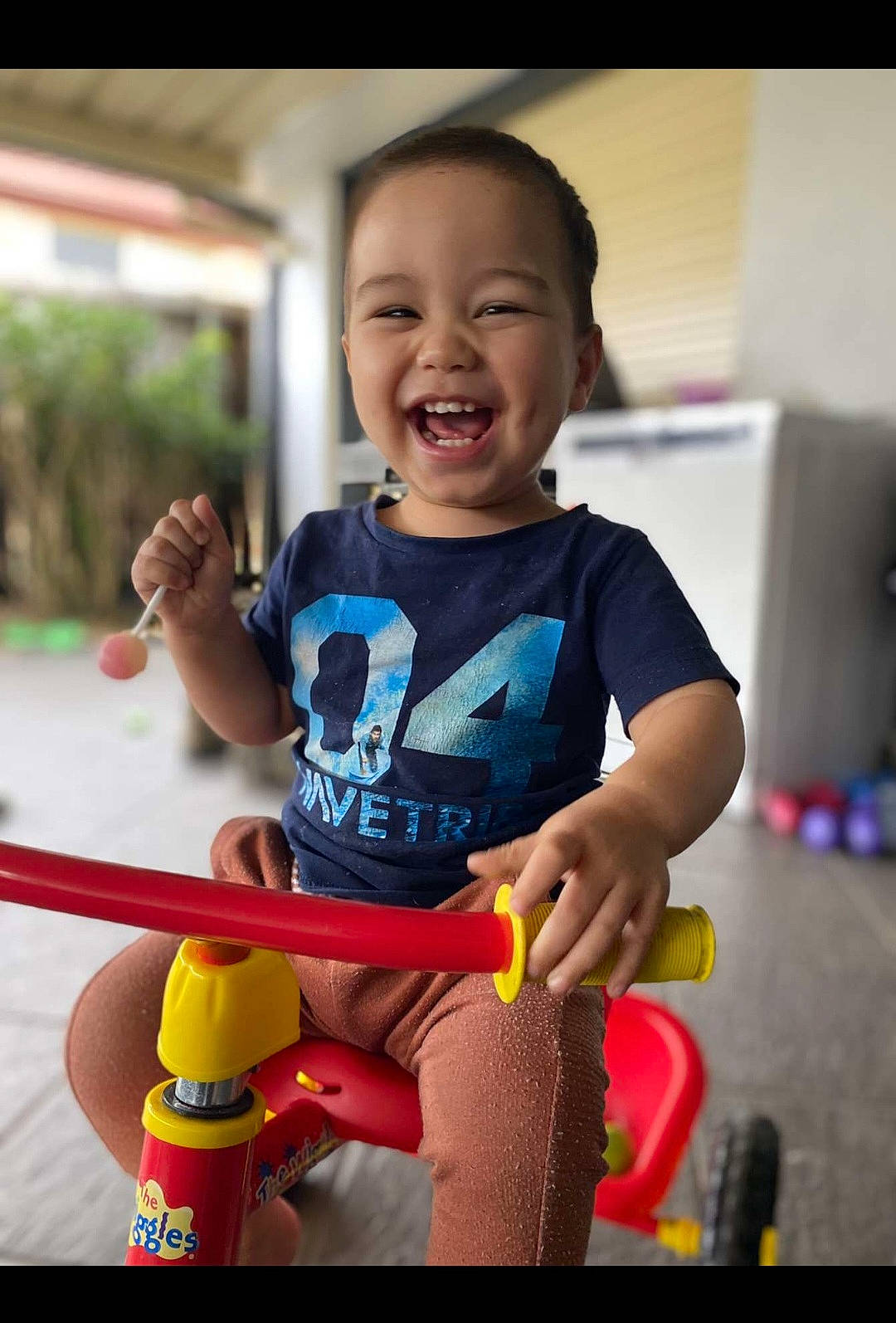 Lucca is registered to the contest to win money with this photo: baby, baby_playing_with_toys, baby_toddler_clothing, child, city, fun, happy, joy, leisure, person, play, recreation, riding_toy, room, shorts, sitting, skin, smile, t_shirt, tire