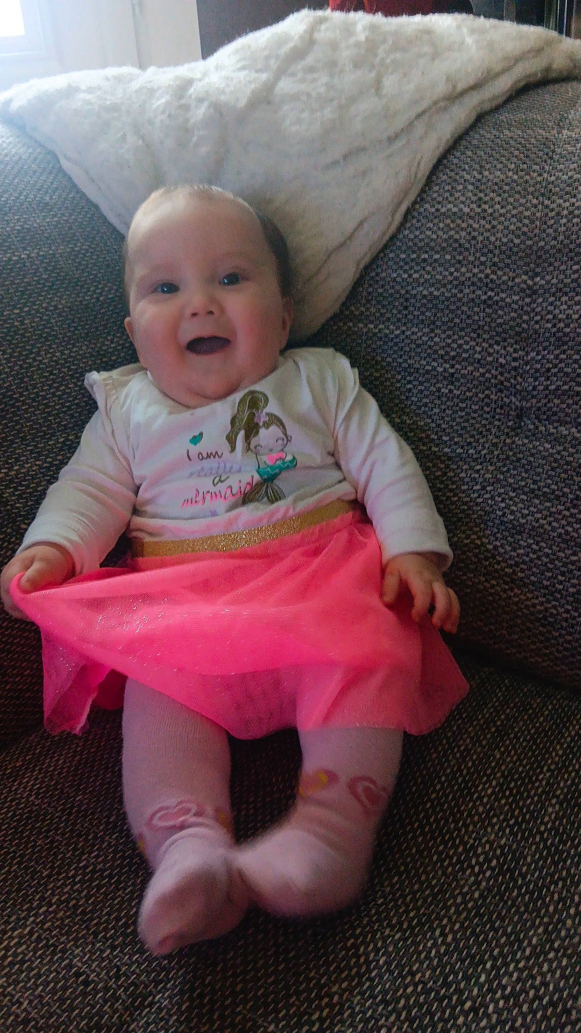 Romane participe au concours pour gagner de l'argent avec cette photo : baby, baby_products, baby_toddler_clothing, cheek, child, comfort, eye, face, fun, happy, leg, linens, magenta, person, pink, sitting, skin, sleeve, smile, t_shirt