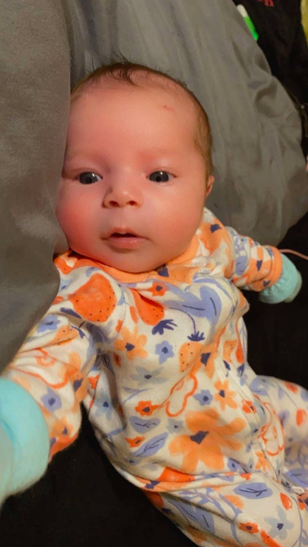 Adelina is registered to the contest to win money with this photo: baby, baby_toddler_clothing, cheek, child, collar, dress, dress_shirt, eye, human_body, lip, nose, orange, pattern, peach, people, person, pink, sitting, skin, sleeve