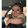 toddler, child, car_seat, car_interior, face, smile, hair_accessory, cute, arm, yellow_shirt, window, daylight, expression, person, baby, seat, car, skin, cheeks, happy