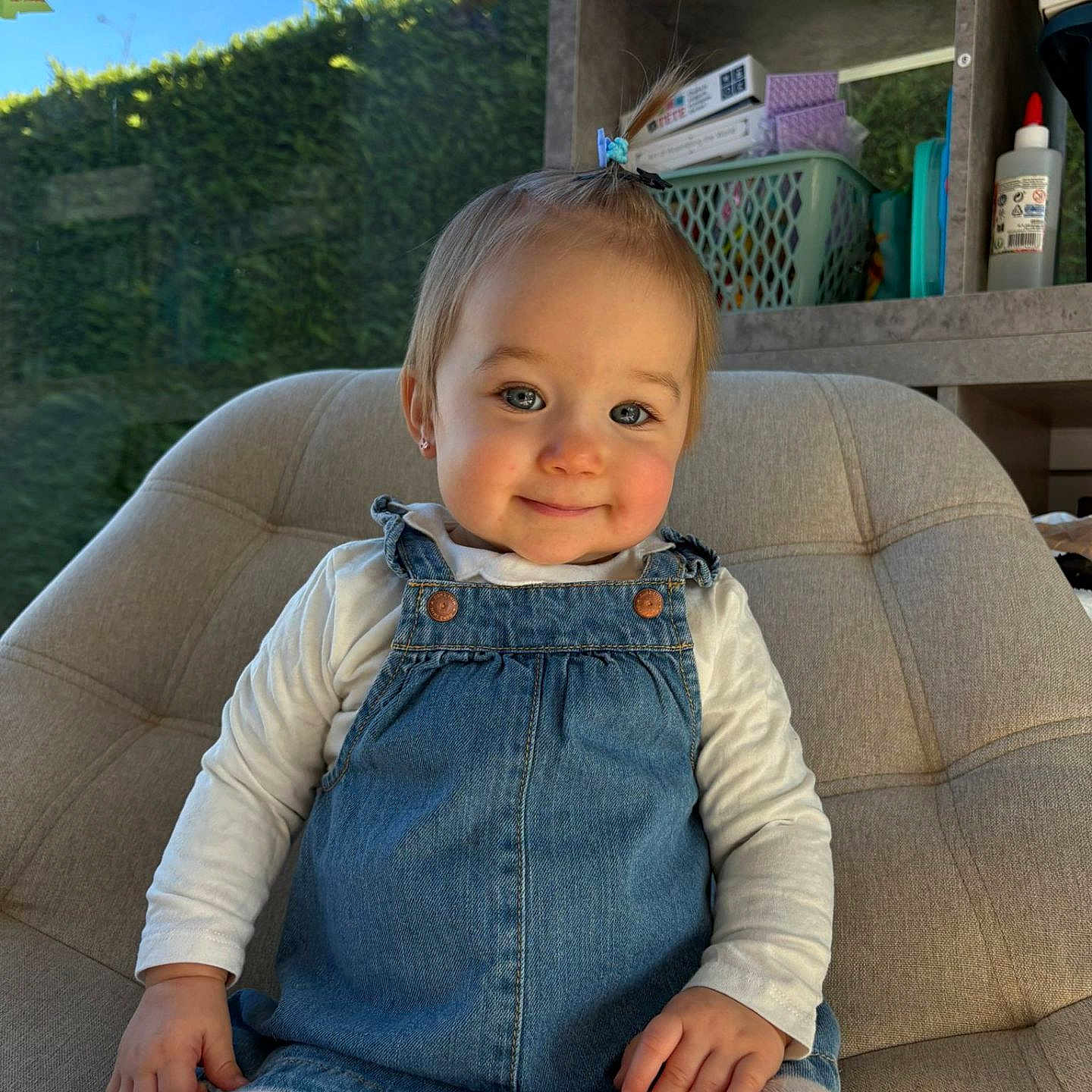 Lilou participe au concours pour gagner de l'argent avec cette photo : baby, blue_eyes, chair, child, denim_dress, glue_bottle, hair_clip, happy, indoor, portrait, rosy_cheeks, shelves, sitting, smile, storage_basket, sunlight, tights, toddler, toy_shelf, white_shirt