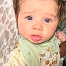 Greyson joined the competition — help win amazing prizes! baby, infant, blue_eyes, green_bib, animal_embroidery, cream_outfit, duck_prints, curly_hair, close_up, face, child, cute, portrait, indoor, patterned_background, clothing, young_child, person, expression, soft_lighting