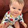 Luis a rejoint le concours — aidez-le/la à gagner de superbes lots ! baby, child, infant, smiling, onesie, animal_print, couch, textured_fabric, indoor, seated, cheerful, cute, soft_toy, white_cloth, happy, portrait, person, skin, head, hand