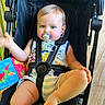 baby, pacifier, stroller, child, indoor, toy, colorful, clothing, seatbelt, flooring, person, cute, infant, smiling, sitting, playful, happy, blue_eyes, short_hair, comfort