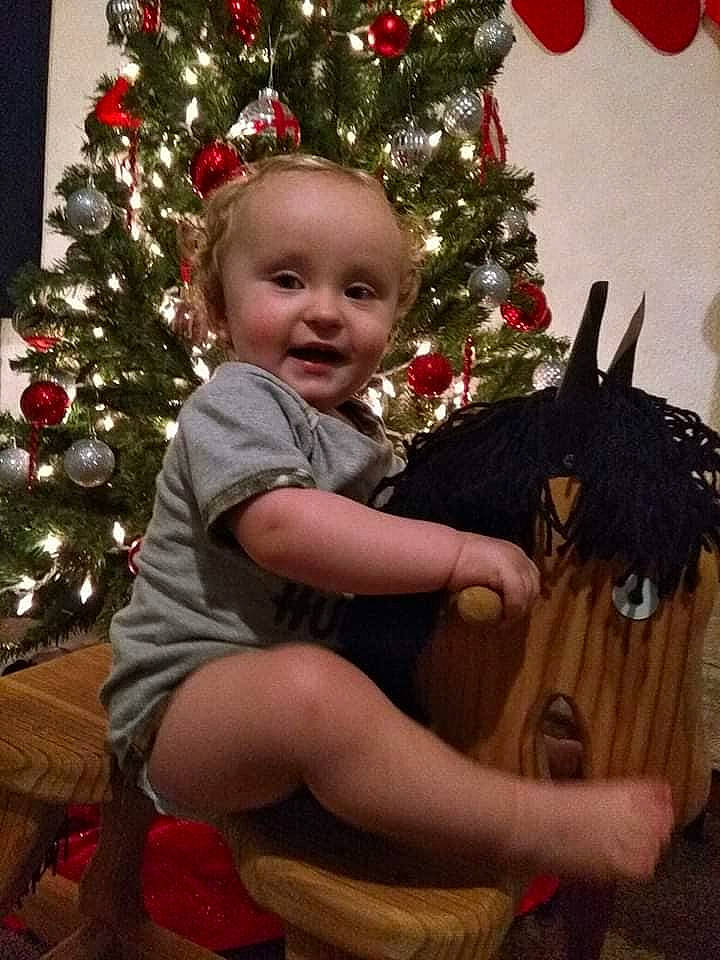 Ernest is registered to the contest to win money with this photo: child, christmas, christmas_decoration, christmas_eve, christmas_ornament, christmas_tree, event, fir, holiday, holiday_ornament, interior_design, person, plant, toddler, tree