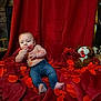 baby, infant, child, jeans, bare_torso, lipstick_kisses, red_petals, red_blanket, red_backdrop, teddy_bear, plush_toy, heart, valentine_theme, dog_face, indoor, portrait, stone_wall, wooden_chair, blanket, cute