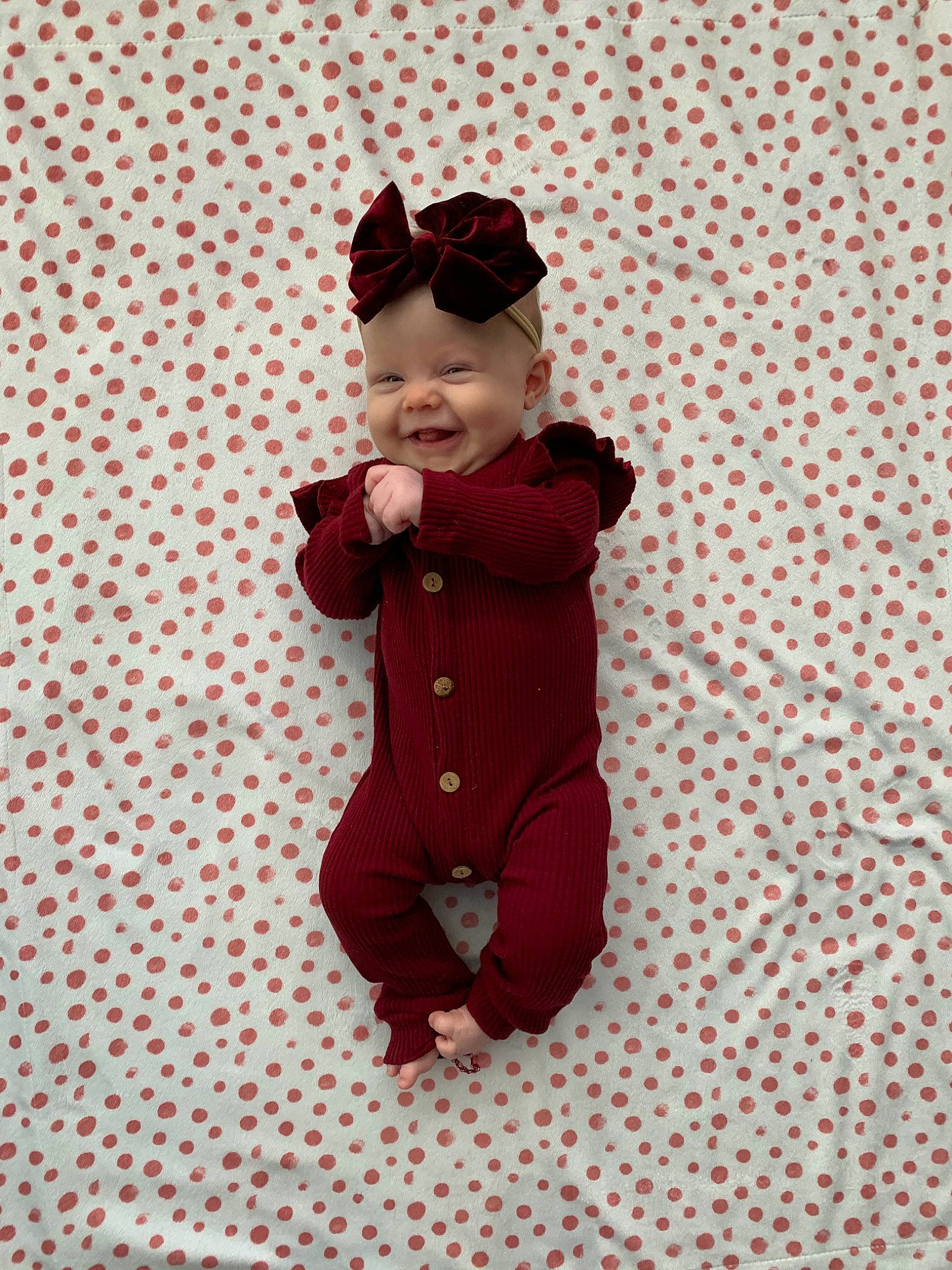 Emerie is registered to the contest to win money with this photo: baby, child, joy, maroon, pajamas, pattern, person, red, sleeve, toddler
