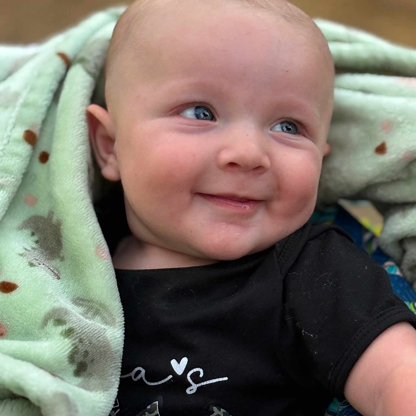 Walker Shackelford joined the competition — help win amazing prizes! baby, black_shirt, blanket, blue_eyes, cheek, clothing, cute, expression, face, happy, head, infant, person, portrait, seated, skin, smile, soft_texture, wrapped, young_child