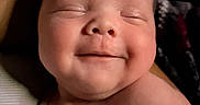 Ronan is registered to the contest to win money with this photo: baby, smiling, face, hand, skin, newborn, infant, cute, closed_eyes, peaceful, portrait, human, child, soft_light, expression, bare_skin, indoors, closeup, sleepy, happy