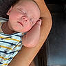 baby, sleeping, arm, onesie, striped_clothing, boat_pattern, bottle, infant, closeup, resting, peaceful, skin, person, furniture, couch, relaxation, newborn, cute, hand, nap