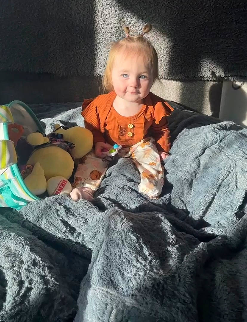 Lilith is registered to the contest to win money with this photo: baby, child, comfort, flash_photography, fun, fur, happy, linens, mammal, monochrome_photography, person, rock, room, sitting, smile, still_life_photography, textile, toddler, tree, vacation