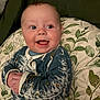 Myles is registered to the contest to win money with this photo: baby, smiling, infant, onesie, cushion, leaf_pattern, happy, portrait, indoors, child, cute, blue_clothing, hands, face, sitting, expression, young_child, comfort, soft_fabric, background